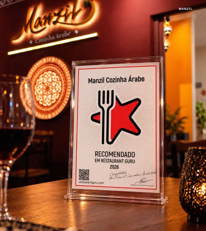 Placa de recomendação Restaurant Guru 2026 exposta no salão do Manzil Cozinha Árabe, em Brasília